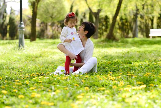 Portrait of mother and little girl playing in the park