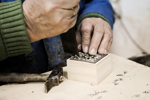 Close-up photgraph of a taracea craftsman working in his workshop