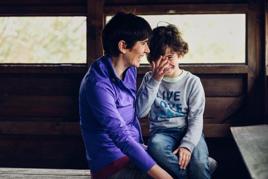 Mother with her seven year old daughter laughing in a cabin in the countryside. Lifestyle concept.