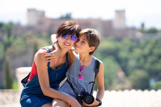 Mother and her little daughter traveling together in Granada, Andalusia, Spain with the Alhambra in the background