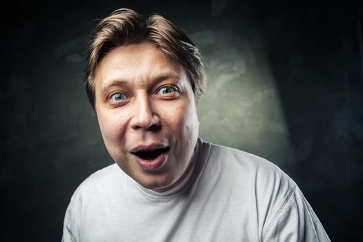 portrait of young beautiful man surprised face expression over gray