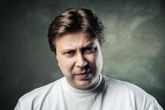 emotional angry middle aged man over dark gray background