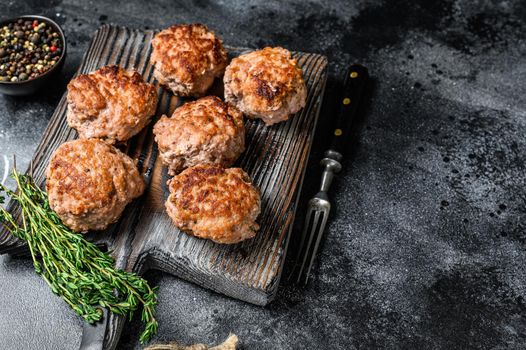 Roasted cutlets from beef and pork meat. Black background. Top view. Copy space.