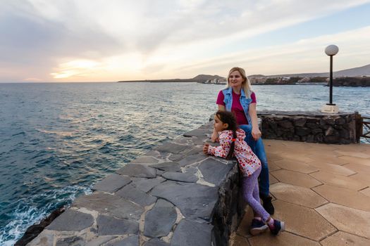 Family holiday on Tenerife, Spain. Mother with children outdoors on ocean. Portrait travel tourists - mom with kids. Positive human emotions, active lifestyles. Happy young family on sea beach