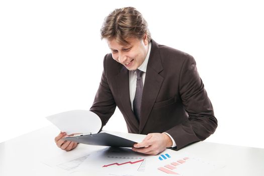 Man wearing suit sitting in desk observing pile of charts