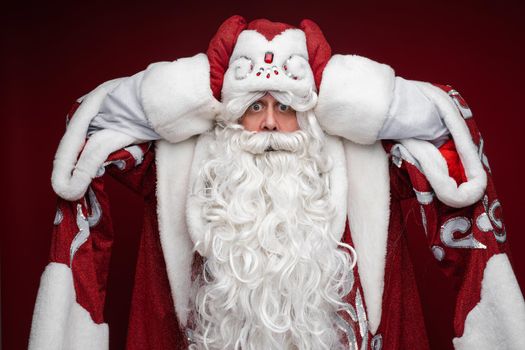 santa claus with long white beard is afraid of something, picture isolated on white background