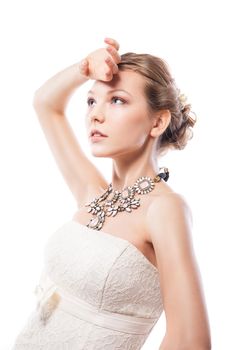 The beautiful young woman posing in a wedding dress. Beauty make-up. Jewellery