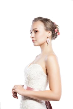 The beautiful young woman posing in a wedding dress. Beauty make-up. Jewellery