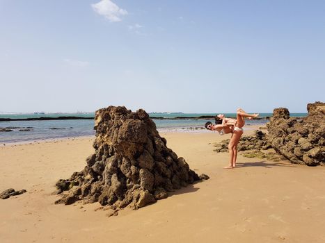 Mother and little daughter having fun on the beach of the Wall of Puerto Sherry, in Puerto de Santa Maria, Cadiz, Andalusia, Spain.