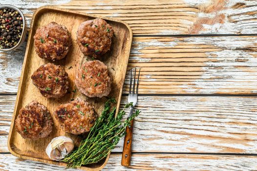 Fried meat chicken cutlets on a wooden tray. White background. Top view. Copy space.