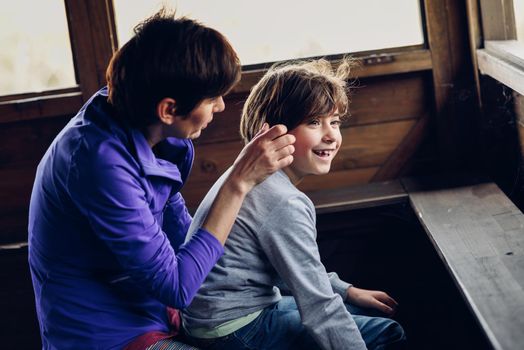 Mother with her seven year old daughter laughing in a cabin in the countryside. Lifestyle concept.