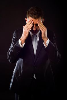 Portrait of a businessman concerned about crisis on black background