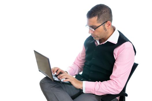 A successful businessman with glasses wearing vest and pink shirt looking at a little computer