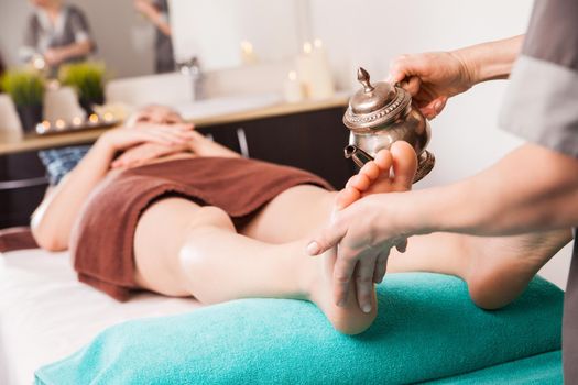 ayurvedic foot therapy massage procedure with oil in spa