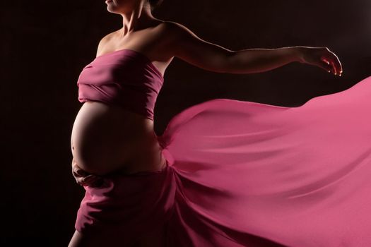 Portrait of beautiful pregnant woman in pink chiffon shawl