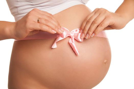 Close up image of pregnant woman tummy with pink ribbon over white
