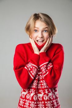 Beautiful young Girl wrapped in a warm knitted warm comfort sweater.