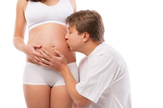 Happy young father kissing the belly of his pregnant wife