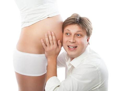 Husband listening to his wife's belly isolated over white