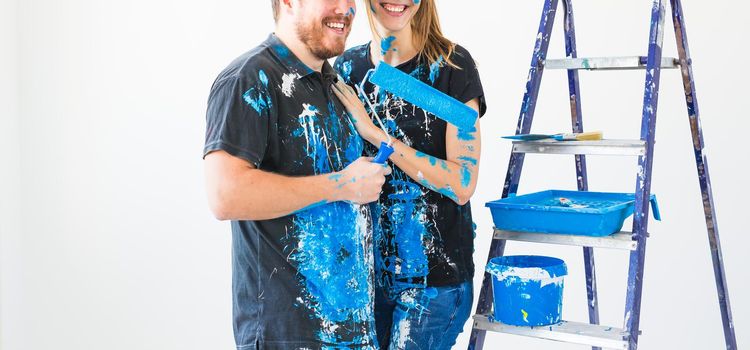 Renovation, repair and family concept - a young couple doing a repair in new home.