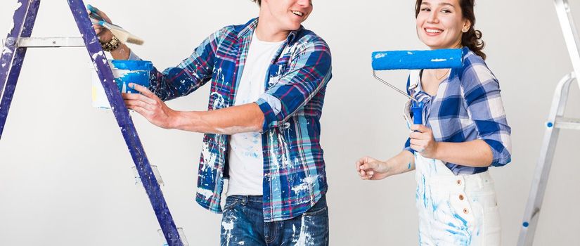 Renovation, repair and people concept - Close up portrait of couple stained with paint over white background.