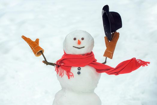 Snowman with hat and scarf in winter outdoor. Hello winter. Happy smiling snow man on sunny winter day