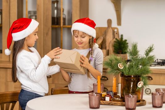 Happy children with gifts. Twins, two little sisters, two similar girls giving presents. Holiday and Christmas concept.