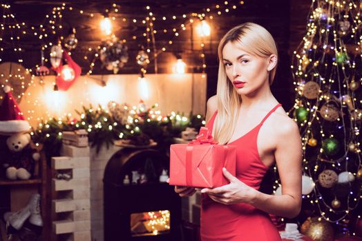 Woman holding gift boxes. Happy woman with Christmas gift over Christmas interior background