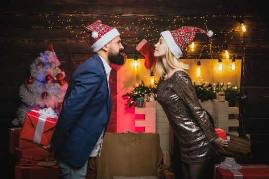 Christmas kiss of couple in love. Portrait of surprised and funny couple. Comic couple with surprise gift