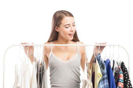 Portrait of smiling brunette looking down at clothes on hanger