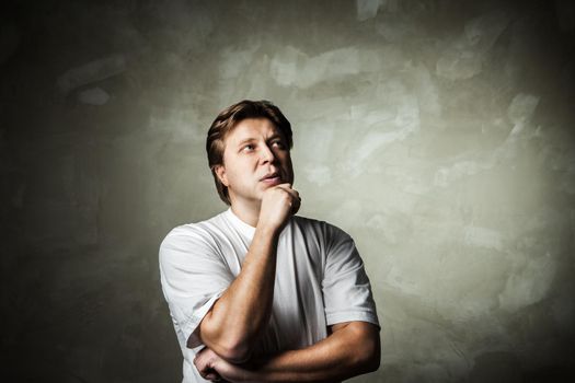 young handsome man doubting over gray background