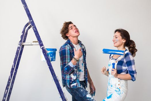 Renovation, repair and family concept - a young couple doing a repair in new home.