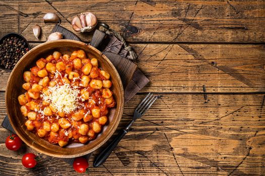 Italian Gnocchi potato pasta in tomato sauce. Wooden background. Top view. Copy space.