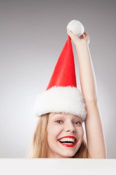 Beautiful christmas woman in santa hat holding empty board isolated on white background