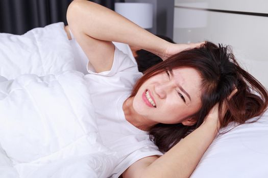 woman having sleepless on bed and having migraine,stress, insomnia, hangover in the bedroom