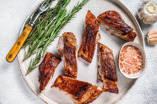 Sliced Grilled veal short spare rib meat with butcher knife. Black background. Top view.