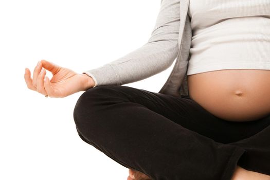 Pregnant woman relax doing yoga, sitting in lotus position over white background