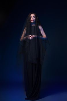 Young gothic female dressed in black looking away.