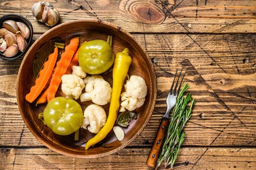 Salted and pickles vegetables preserve in a wooden plate. wooden background. Top view. Copy space.