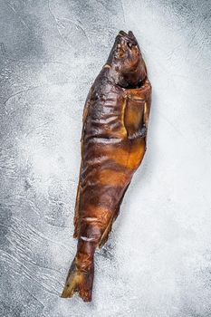 Hot smoked whole fish on kitchen table. White background. Top view.