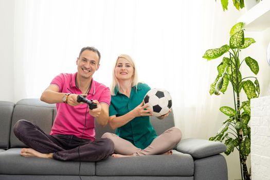 Man and woman playing video games with joystick at home.