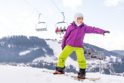 Little Cute Girl Snowboarding at ski resort in sunny winter day. Caucasus Mountains. Mount Hood Meadows Oregon