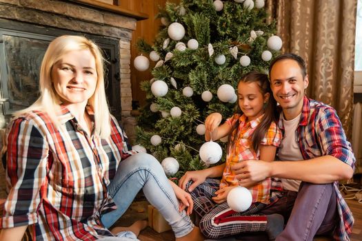 family and christmas tree in an old wooden house