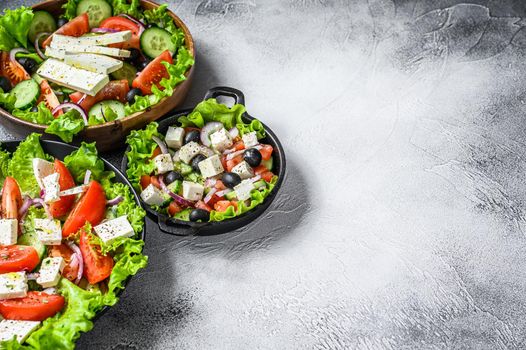 Set of ready-to-eat Greek salad in a bowl. White background. Top view. Copy space.