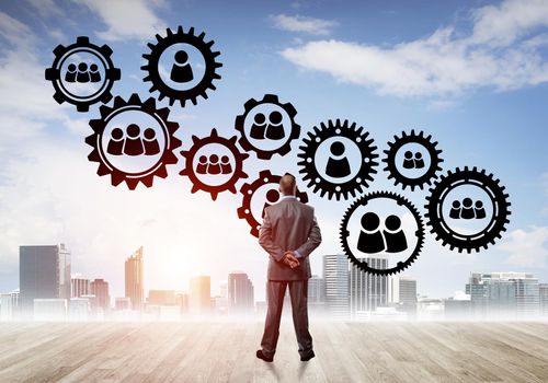 Back view of businessman looking at modern cityscape and gear connection idea