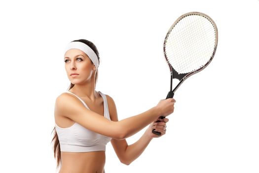 Adult woman playing tennis and going to make a stroke. Studio shot over white.
