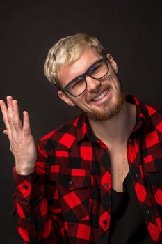 Man in red shirt in cage with glasses on black background. Studio shot