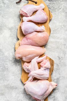 Raw uncooked chicken meat on a cutting board. Gray background. Top view.