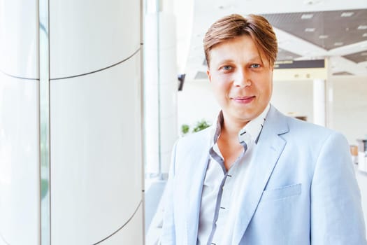 Portrait of handsome smiling business man in urban setting