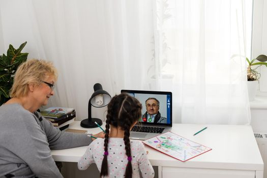 Helpful granny. Helpful loving granny assisting her cute granddaughter making homework